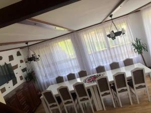 a dining room with a white table and chairs at Casa pintioi in Ieud