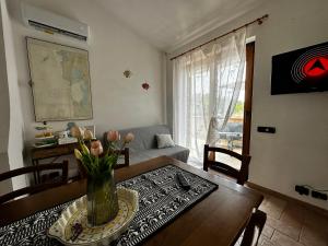 una sala de estar con una mesa con un jarrón de flores en Crock House en Funtana Meiga