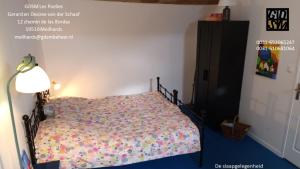 ein Schlafzimmer mit einem Bett mit einer bunten Bettdecke in der Unterkunft Gite Meilhards in Meilhards