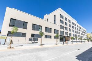 un edificio blanco con árboles delante de él en Micampus Getafe, en Getafe