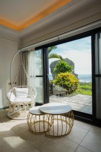 a room with a swing table and a view of the ocean at 墾丁曜星海Villa-海景第一排 in Hengchun