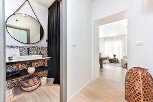 ein Bad mit einem Spiegel und einem Waschbecken im Zimmer in der Unterkunft Luxury Apartment Sunce in Rovinj