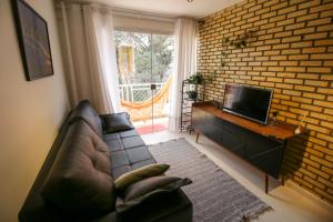 uma sala de estar com um sofá de couro e uma televisão em FLAT W3 Norte em Brasília