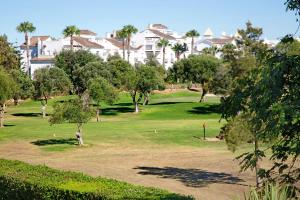 un campo da golf di fronte a un grande edificio di Casa en Costa Ballena a Rota
