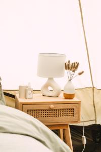 a bedside table with a lamp on it next to a bed at Stoffhaus in Skipton