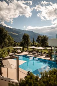 ein großer Pool mit Stühlen und Sonnenschirmen in der Unterkunft Hotel Hanswirt in Rabland