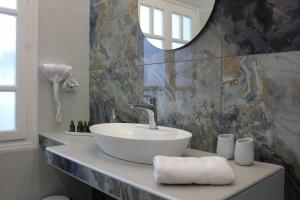 La salle de bains est pourvue d'un lavabo et d'un miroir. dans l'établissement THE ROCK LUXURY HOMES, à Mesariá