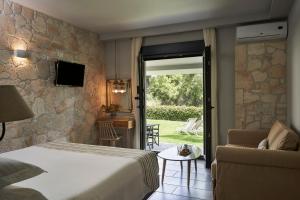 sypialnia z łóżkiem i kanapą oraz patio w obiekcie Mirabilia Boutique Hotel w mieście Kriopigi