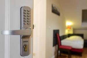 a door with a door knob and a room with a bed at Dworek Różany Hotel & Restauracja in Namysłów