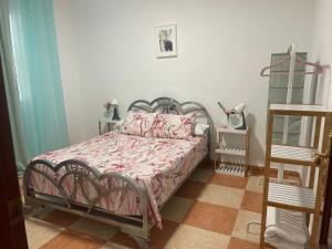 a bedroom with a bed with a pink comforter at La casita del pueblo in Molvízar
