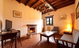 a living room with a fireplace and a table at HOTEL RURAL ARREDONDO in Celorio +14 photos
