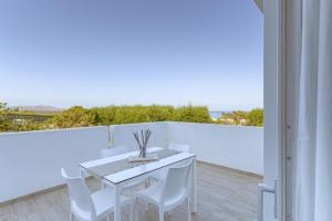 a white table and white chairs on a balcony at Stunning Capo Falcone Charming Apartments 2 Bedrooms sleeps 6 in Stintino