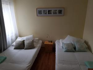 a living room with two white beds and a table at Syrenka Apartamenty in Ustka