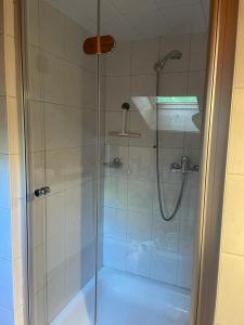 a shower with a glass door in a bathroom at LA FAVELA in Cully +8 photos