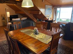 a dining room with a wooden table and chairs at LA FAVELA in Cully
