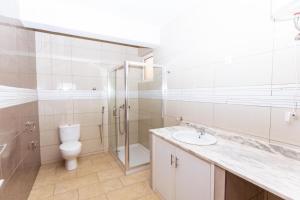 a bathroom with a toilet and a sink and a shower at Maya Apartments in Mindelo