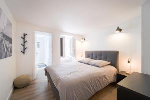 a bedroom with a large bed in a white room at Appart' Terrasse plein centre in La Ferté-Gaucher