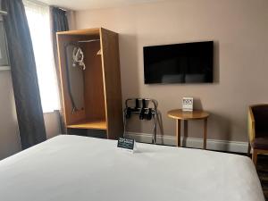 a hotel room with a bed and a flat screen tv at The Golden Lion Wetherspoon in Rochester