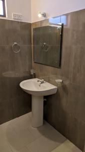 a bathroom with a sink and a mirror at Verandas Trincomalee in Trincomalee