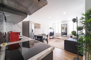 eine Küche und ein Wohnzimmer mit einem Sofa und einem Tisch in der Unterkunft Appart' Terrasse plein centre in La Ferté-Gaucher