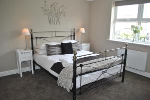 Schlafzimmer mit einem Bett mit weißer Bettwäsche und Kissen in der Unterkunft Two Bedroom Windsor Flats with Parking in Windsor