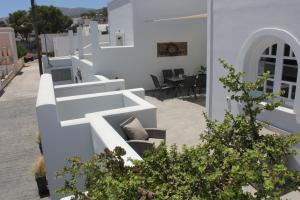 a white house with a patio with a table and chairs at THE ROCK LUXURY HOMES in Mesaria