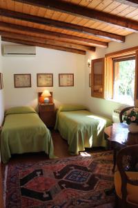 een slaapkamer met 2 groene bedden en een raam bij Villa San Bartolomeo in San Gregorio di Catania