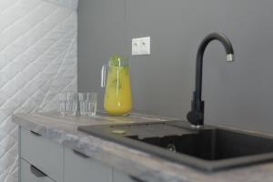 a sink with a bottle of orange juice next to glasses at Glamping Resort in Dolný Kamenec