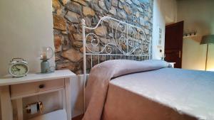 een bed in een kamer met een stenen muur bij Il Bordone del Pellegrino in Terenzo