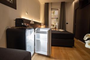 a small room with a refrigerator and a bed at Contemporaneamente 147 - Modern & Comfort Rooms in Bari