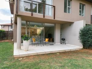 a house with a porch with a table and chairs at Zimbali Wedge - Unit 29 in Ballito