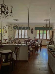 uma sala de jantar com mesas e cadeiras e um lustre em Hotel Amandi em O Grove