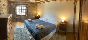 a bedroom with a bed with two towels on it at Vila-seca, vine i desconnecta! in Aguilar de Segarra
