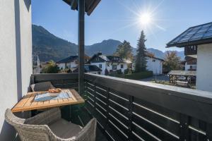 a table and chairs on a balcony with a view at Landhaus Ohrwumslar in Oberstdorf