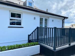 a white house with a black railing on a balcony at Stunning new fully renovated flat in Marazion in Marazion