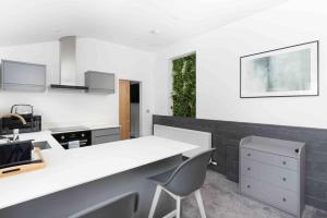 a kitchen with a white counter and some chairs at Stunning new fully renovated flat in Marazion in Marazion