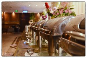 a row of wine glasses on a counter with flowers at فندق الاندلس الماسى in Al Madinah