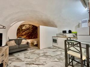a living room with a couch and a kitchen at Cave House Apartment in Menton