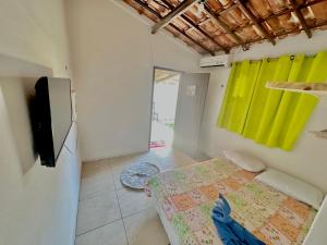 a bedroom with a bed and a flat screen tv at Pousada Casa Eco Paracuru in Paracuru