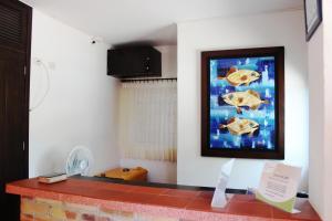 a living room with a painting of fish on the wall at Hotel San Marcos Taganga in Taganga