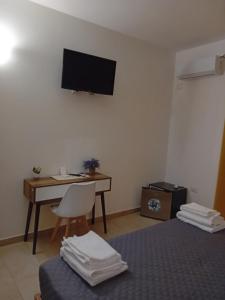 a hotel room with a desk and a bed and a television at Eliseo's rooms in Triei