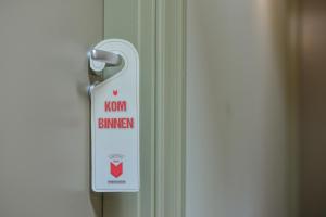 un cartel en una puerta que dice quemador de hierro en Hotel Frederiksoord en Frederiksoord
