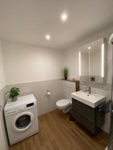 a bathroom with a washing machine and a sink at Ferienwohnung Zur alten Dorfschule in Lünebach