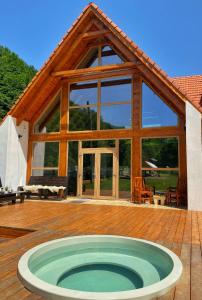 a house with a hot tub on a wooden deck at Scrind 11 - Madleine Chalet in Cluj-Napoca