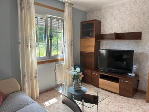 ein Wohnzimmer mit einem Sofa und einem TV in der Unterkunft Casa ceferino in Barreiros