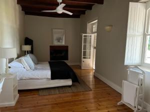 1 dormitorio con 1 cama y ventilador de techo en Hartebeeskraal Selfcatering cottage, en Paarl