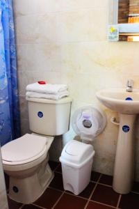 Hotel San Marcos Taganga في تاجانجا: حمام مع مرحاض ومغسلة