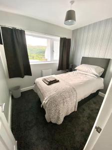 um quarto com uma cama grande e uma janela em Bryn Mair cottage overlooking Snowdon em Caernarfon