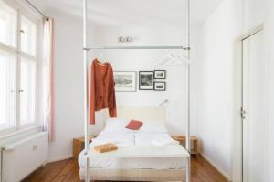 a white bedroom with a white bed and a window at Apartments elPilar Friedrichshain in Berlin