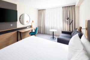 una camera d'albergo con letto e sedia di Holiday Inn Coventry M6, J2, an IHG Hotel a Coventry